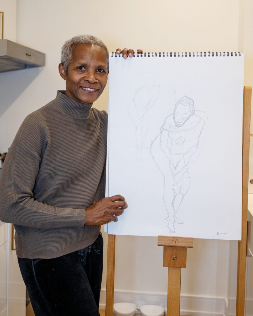 A woman holding an empty easel with a drawing of a man.